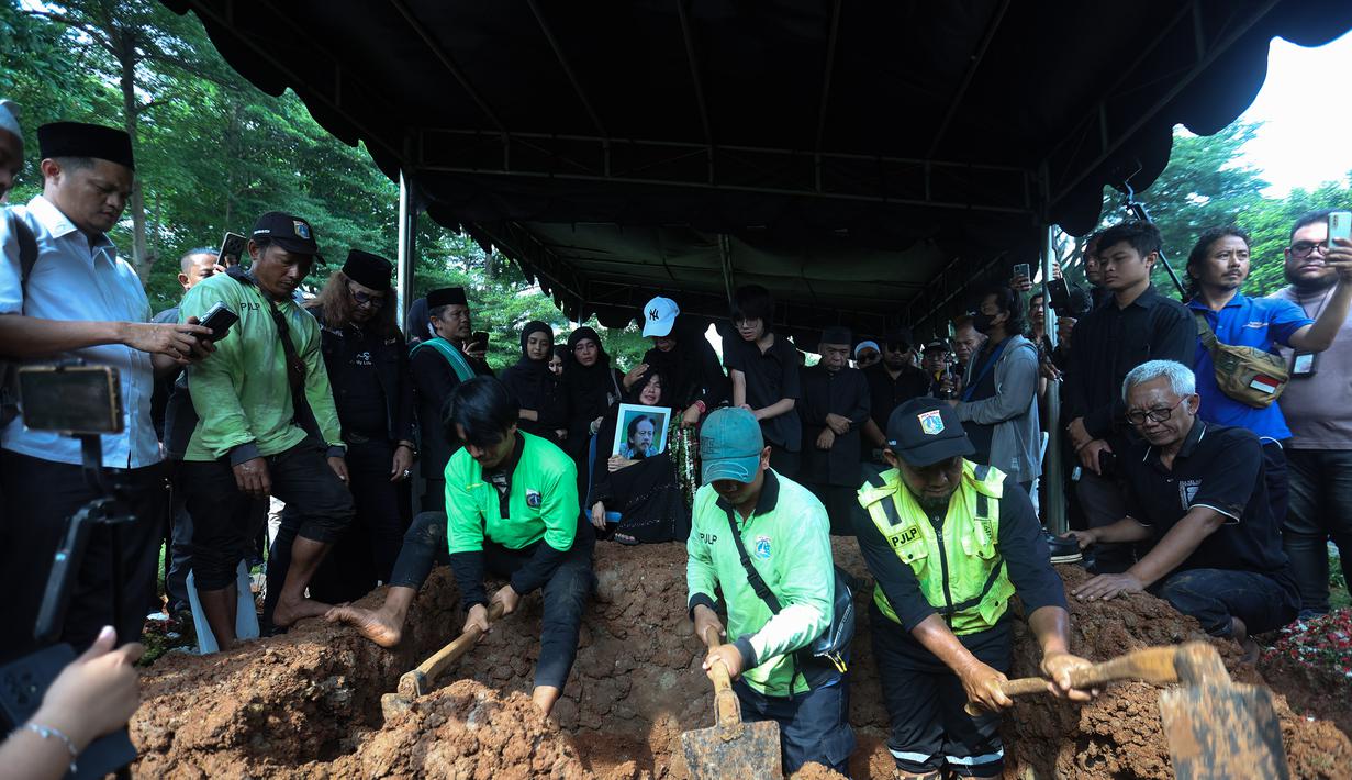 Prosesi pemakaman berlangsung khidmat dan penuh haru. Tampak dalam foto, Karina Ranau bersama Quentin Stanislavski saat menyaksikan pemakaman Epy Kusnandar di Tempat Pemakaman Umum (TPU) Jeruk Purut, Jakarta Selatan, Kamis (4/12/2025) pagi. (Kapanlagi.com/Budy Santoso)