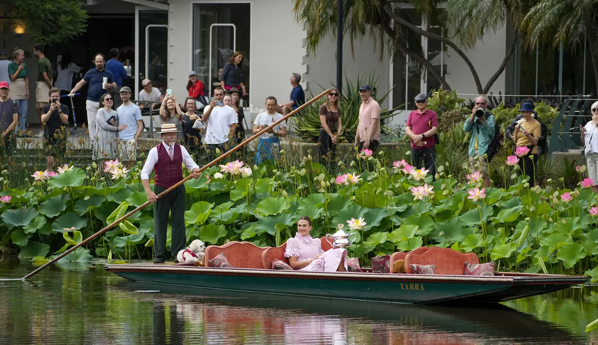 Petenis tunggal putri Belarusia, Aryna Sabalenka menaiki perahu di Royal Botanical Gardens dengan trofi Daphne Akhurst Memorial Trophy setelah menjadi juara pada Australia Open 2023 di Melbourne, Australia, Senin (30/01/2023). Sabalenka berhasil mengalahkan petenis Khazakstan, Elena Rybakina di babak final dengan skor 4-6, 6-3, 6-4. (AP Photo/Aaron Favila)