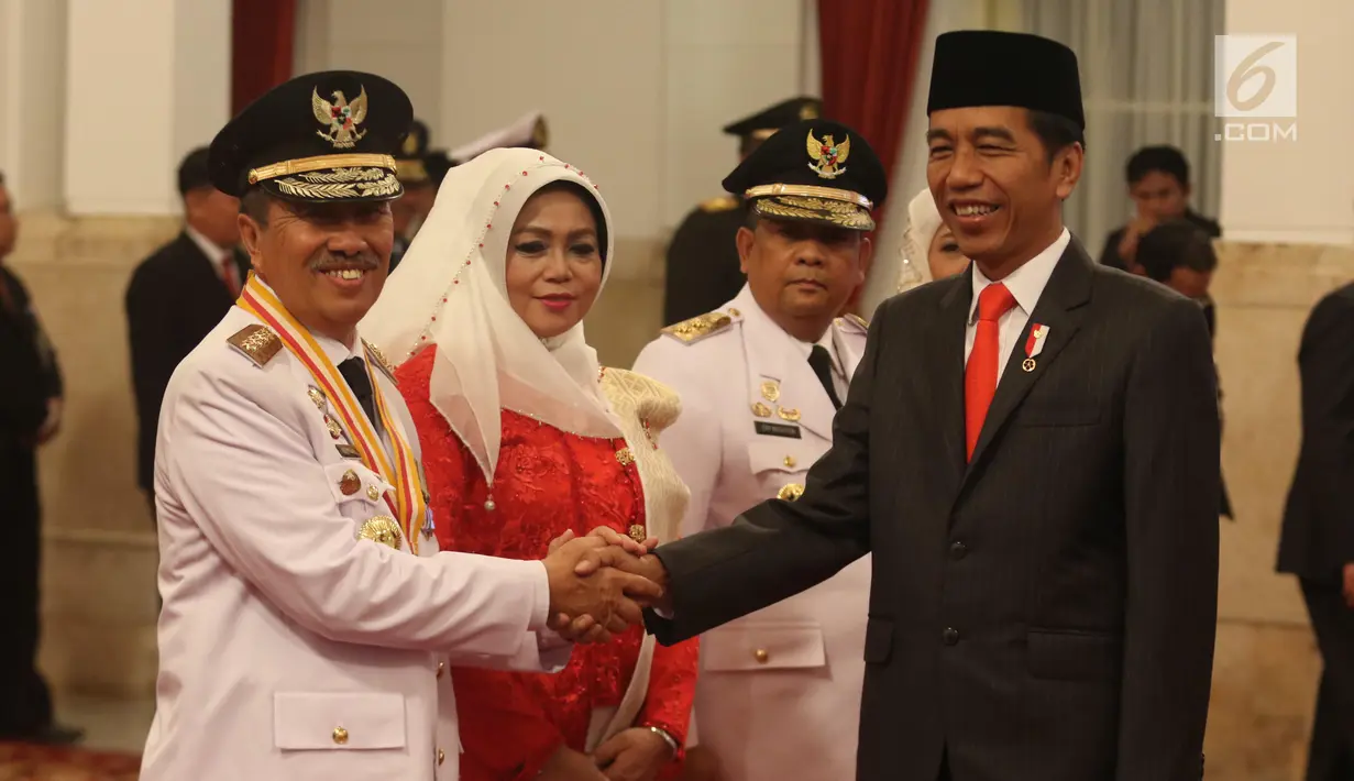 Presiden Joko Widodo atau Jokowi (kanan) menyalami Gubernur Riau Syamsuar saat pelantikan di Istana Negara, Jakarta, Rabu (20/2). Syamsuar dilantik menjadi Gubernur Riau periode 2019-2024. (Liputan6.com/Angga Yuniar)