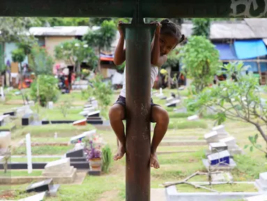 Seorang anak bermain di sekitar TPU Karet Bivak, Jakarta, Jumat (13/1). Semakin berkurangnya lahan hijau menyebabkan anak-anak di Ibukota terpaksa bermain di tempat yang tidak semestinya. (Liputan6.com/Immanuel Antonius)