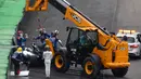 Petugas mengangkat mobil Lewis Hamilton usai menabrak dinding pembatas lintasan saat kualifikasi F1 GP Brasil di sirkuit Interlagos di Sao Paulo, Brasil (11/11). Hamilton gagal finis di kualifikasi GP Brasil. (AFP Photo/Nelson Almeida)