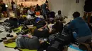 Wisatawan asing tidur di lantai saat menunggu jadwal keberangkatan pesawat di Bandara Internasional Praya Lombok, NTB, Senin (6/8). Imbas gempa 7 SR, para wisatawan terlantar di bandara karena jam pemberangkatan pesawat yang tertunda (AFP/SONNY TUMBELAKA)