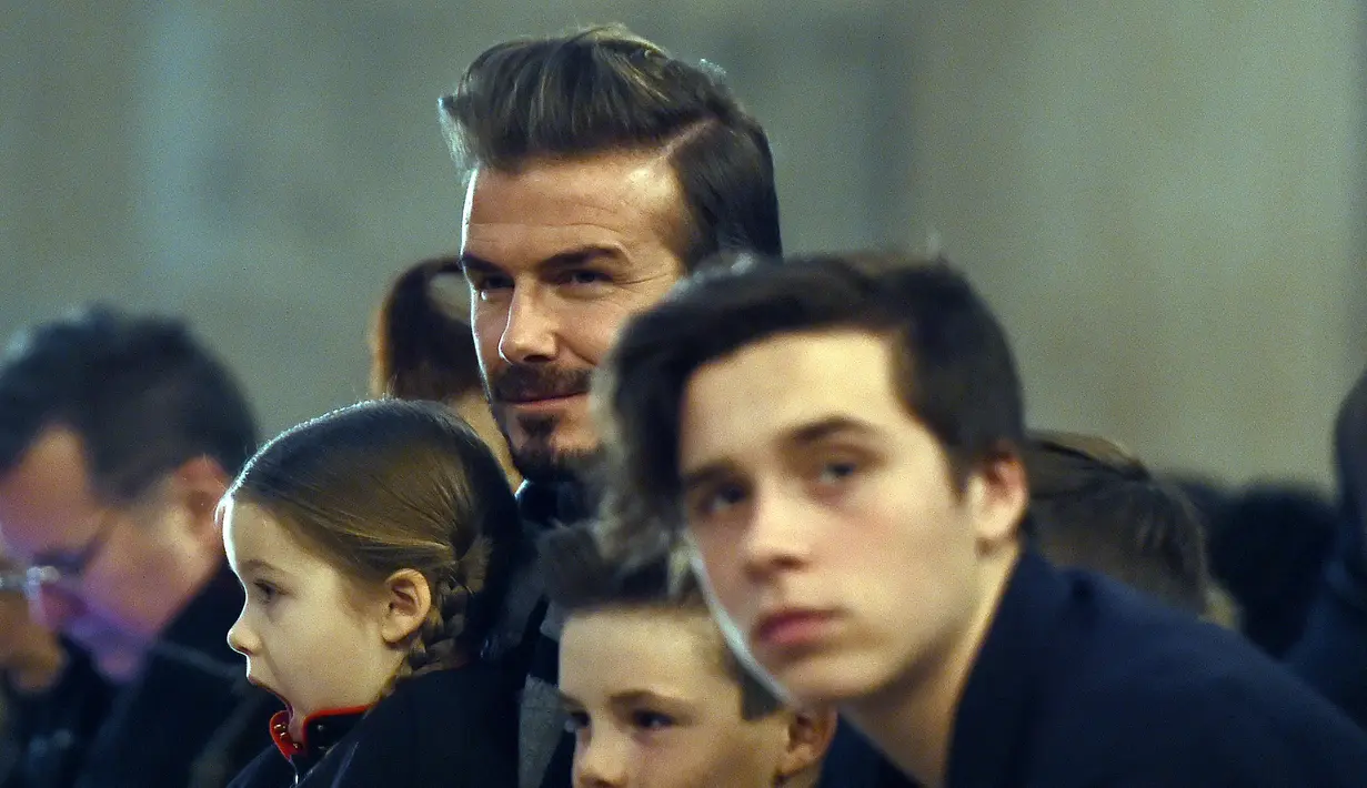 David Beckham terlihat serius mengamati koleksi busana terbaru milik sang istri Victoria Beckham Fall/Winter 2016 bersama anak-anaknya Harper, Cruz, Romeo dan Brooklyn di New York Fashion Week (14/2). (AFP/Jewel Samad)