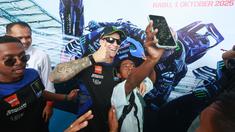 Pembalap Monster Energy Yamaha, Fabio Quartararo, foto bersama siswa saat mengunjungi SMAN 2 Mataram, Nusa Tenggara Barat (NTB), Rabu (1/10/2025). (Bola.com/M Iqbal Ichsan)