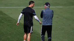 Cristiano Ronaldo (kiri) berbincang dengan pelatih Carlo Ancelotti saat sesi latihan di Stadion Santiago Bernabeu, Spanyol (12/5/2015). Real Madrid akan menantang Juventus di leg kedua semifinal Liga Champions. (Reuters/ Juan Medina)