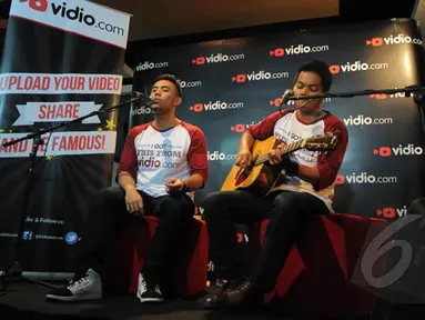 Pemenang ketiga dan kedua Music Video Contest, Eros Tjokro  (kiri) dan Dibya Dika (kanan) saat berduet di kantor Vidio.com, SCTV Tower, Jakarta, Rabu (28/1/2015). (Liputan6.com/Herman Zakharia)