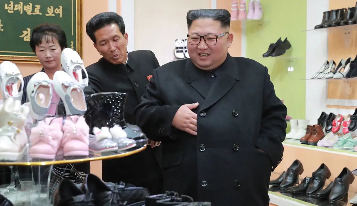 Pemimpin Korea Utara, Kim Jong-Un melihat sepatu saat mengunjungi pabrik sepatu Wonsan, Korea Utara (3/12). (Photo by KCNA VIA KNS / various sources / AFP)