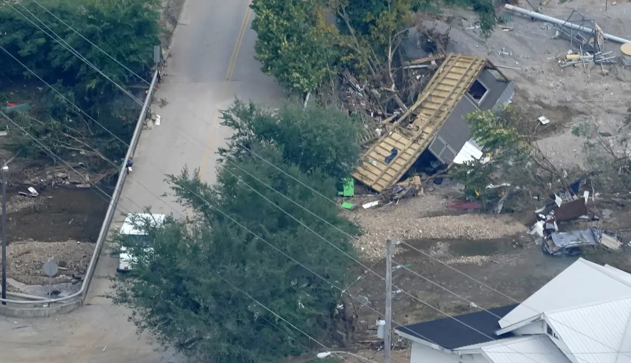 Sebuah bangunan tersangkut di jembatan di Waverly, Tennessee, Rabu (25/8/2021). Hujan deras selama akhir pekan menyebabkan banjir di Tennessee Tengah dan telah mengakibatkan puluhan orang tewas karena rumah dan jalan pedesaan hanyut. (AP Photo/Mark Humphrey)