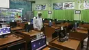 Petugas melakukan penyemprotan cairan disinfektan jelang dibukanya pembelajaran tatap muka di SMK PB Soedirman 2, Jakarta, Selasa (6/4/2021). Pemprov DKI Jakarta akan melakukan uji coba pembelajaran tatap muka di 100 sekolah mulai 7 April hingga 29 April 2021. (Liputan6.com/Herman Zakharia)