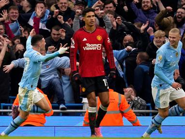 Reaksi pemain Manchester United Raphael Varane (tengah) saat Erling Haaland (kanan) dan Phil Foden merayakan gol ketiga Manchester City pada pertandingan sepak bola Liga Premier Inggris di Stadion Etihad, Manchester, Inggris, Minggu, 3 Maret 2024. (AP Photo/Dave Thompson)