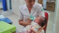 Bayi bongsor Manado menikmati susu perawat (Liputan6.com / Yoseph Ikanubun)