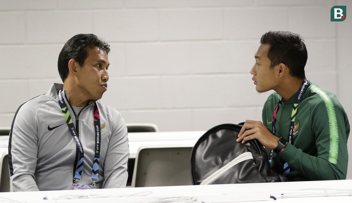 Pelatih Timnas Indonesia, Bima Sakti, berbincang dengan Hansamu Yama, saat jumpa pers jelang laga Piala AFF 2018 di Stadion Nasional, Singapura, Kamis (8/11). Timnas akan berhadapan dengan Singapura. (Bola.com/M. Iqbal Ichsan)