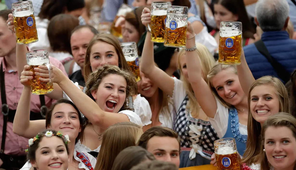 Para wanita muda mengangkat gelas bir saat pembukaan festival bir terbesar di dunia Oktoberfest ke-185 di Munich, Jerman, Sabtu (22/9). (AP Photo/Matthias Schrader)