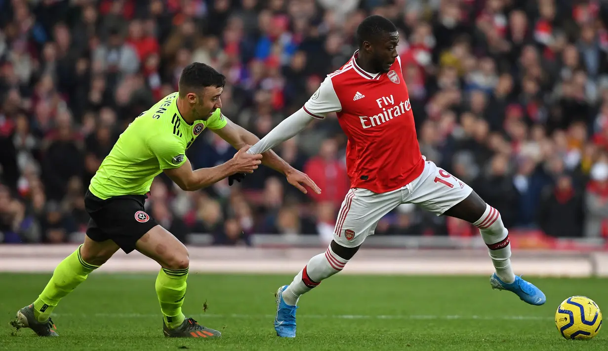 Pemain Arsenal Alexandre Lacazette (kanan) berebut bola dengan pemain Sheffield United Enda Stevens pada pertandingan Liga Inggris di Emirates Stadium, London, Inggris, Sabtu (18/1/2020). Pertandingan berakhir 1-1. (Daniel LEAL-OLIVAS/AFP)