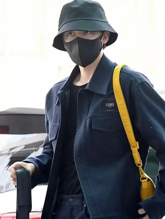 Senada dengan Jeno, Jaemin juga tak kalah kece mengenakan jaket, t-shirt, celana panjang, dan bucket hat warna hitam. Tas warna kuning menjadi statement pada penampilan airportnya itu. (Instagram/nctzenarea).