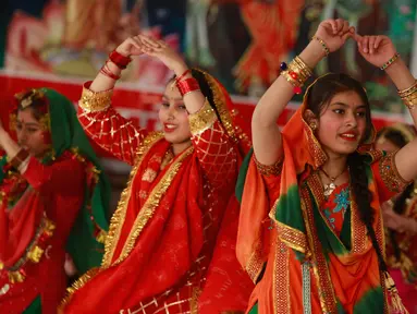 Gadis-gadis India mengenakan pakaian tradisional menari saat mereka merayakan festival Lohri di Jammu, India (13/1). Lohri adalah sebuah perayaan Punjabi populer yang merayakan titik balik musim dingin. (AP Photo / Channi Anand)
