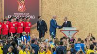 Presiden Rusia Vladimir Putin berjabat tangan dengan Presiden FIFA, Gianni Infantino usai memperlihatkan trofi Piala Dunia dalam pembukaan upacara  "FIFA World Cup Trophy Tour" di stadion Luzhniki di Moskow (9/9). (AFP Photo/Mladen Antonov) 