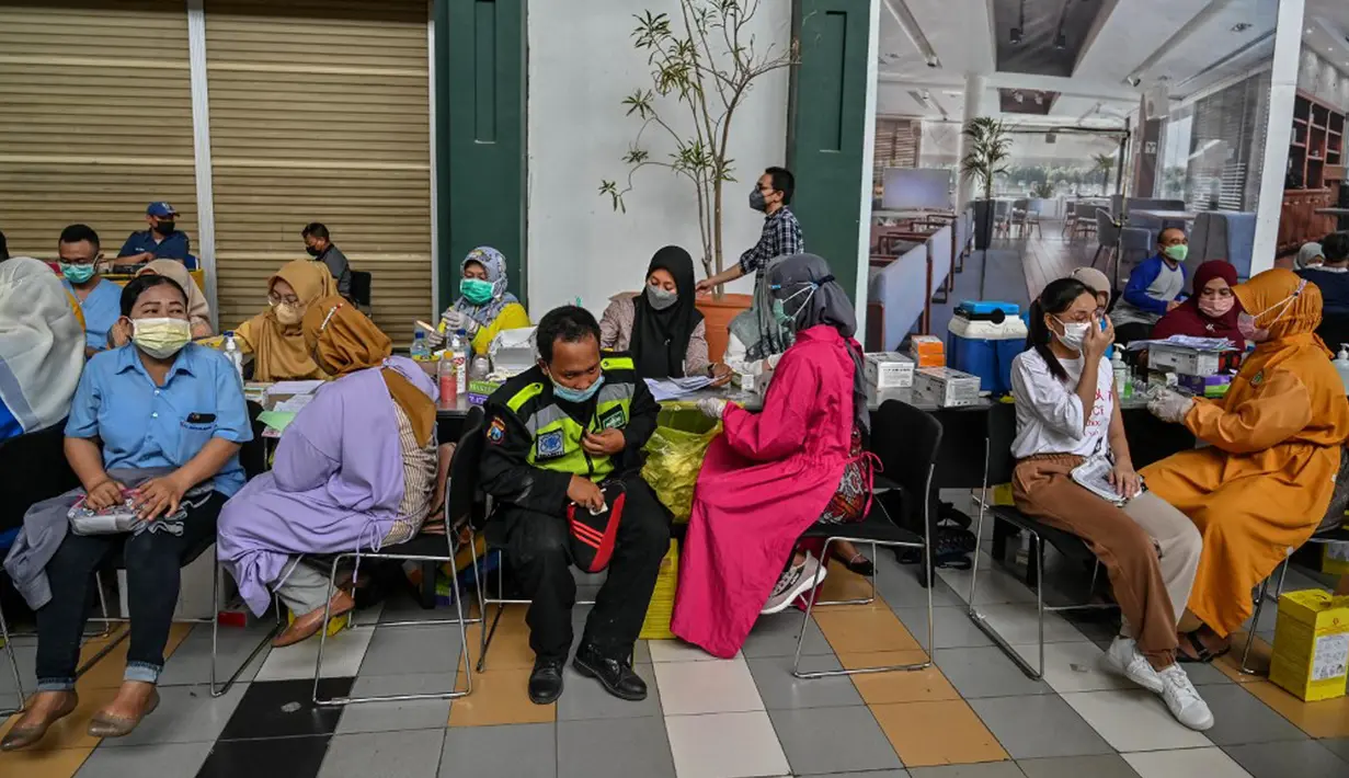 Warga menerima dosis vaksin virus corona COVID-19 Sinovac di sebuah mal di Surabaya, Jawa Timur, Kamis (23/9/2021). Vaksinasi COVID-19 di Surabaya dilakukan di fasilitas kesehatan, mal, perkantoran, kelurahan hingga balai RW. (Juni Kriswanto/AFP)