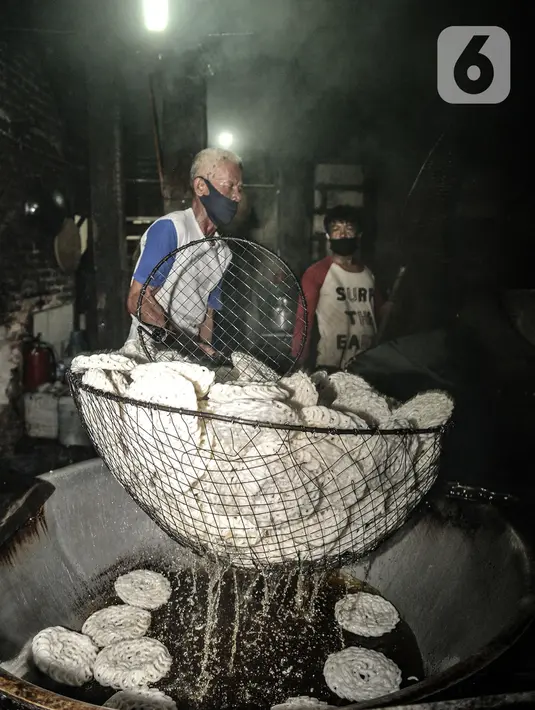 Pekerja menggoreng kerupuk saat produksi rutin di industri rumahan kawasan Cipinang Melayu, Jakarta, Selasa (16/2/2021). Irwan (42), pemilik industri kerupuk itu mengungkapkan akibat Covid-19 yang berkepanjangan menyebabkan penjualan kerupuk anjlok hingga 60 persen. (merdeka.com/Iqbal S Nugroho)