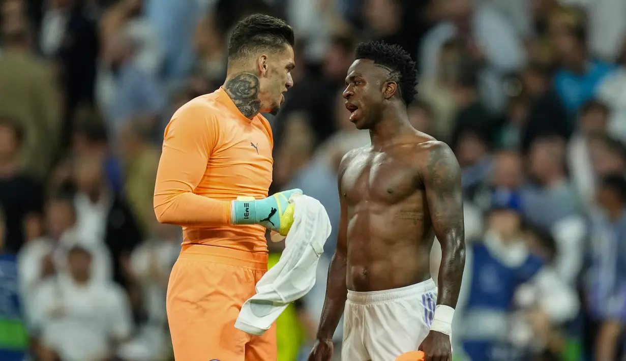 Penjaga gawang Manchester City, Ederson Moraes (kiri), dan pemain Real Madrid, Vinicius Junior, berbincang setelah pertandingan leg pertama Liga Champions 2022/2023 yang berlangsung di Santiago Bernabeu stadium, Rabu (10/5/2023) dini hari WIB.Keduanya merupakan kompatriot di Timnas Brasil. (AP Photo/Jose Breton)