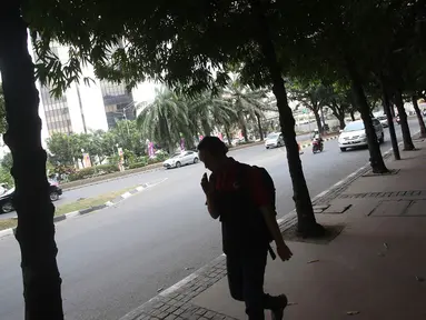 Pejalan kaki melintas di Jalan Sudirman, Jakarta, Selasa (19/9). Terkait pembangunan trotoar, Sekda DKI Saefullah mengatakan ribuan pohon akan dipindahkan ke lokasi yang merupakan aset Pemprov DKI, seperti Taman BMW. (Liputan6.com/Immanuel Antonius)