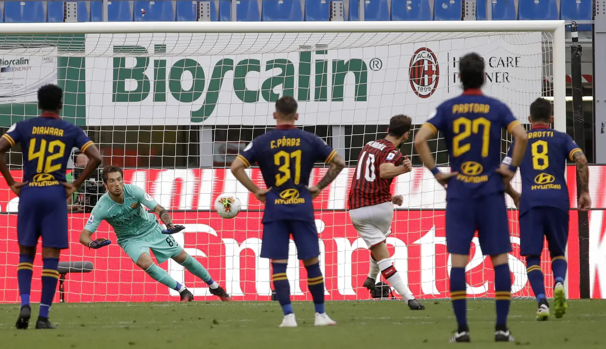 Pemain AC Milan Hakan Calhanoglu (ketiga kanan) mencetak gol ke gawang AS Roma lewat tendangan penalti pada pertandingan Serie A di Stadion San Siro, Milan, Minggu (28/6/2020). AC Milan naik ke posisi 7 klasemen dengan 42 poin usai mengalahkan AS Roma 2-0. (AP Photo/Luca Bruno)