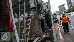 Pekerja membawa puing pos Polisi Sarinah, Jakarta, Jumat (15/1/2016). Pasca teror bom di Pos Polisi Sarinah yang hancur, mulai dibersihkan dan diperbaiki. (Liputan6.com/Faizal Fanani)