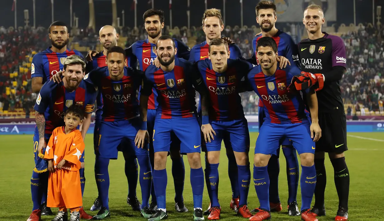 Bocah Afghanistan, Murtaza Ahmadi (depan kiri) berfoto bersama Lionel Messi dan tim Barcelona lainnya sebelum pertandingan persahabatan melawan Al-Ahli di ibu kota Qatar, Doha, Selasa (13/12). (Karim Jaafar/AFP)