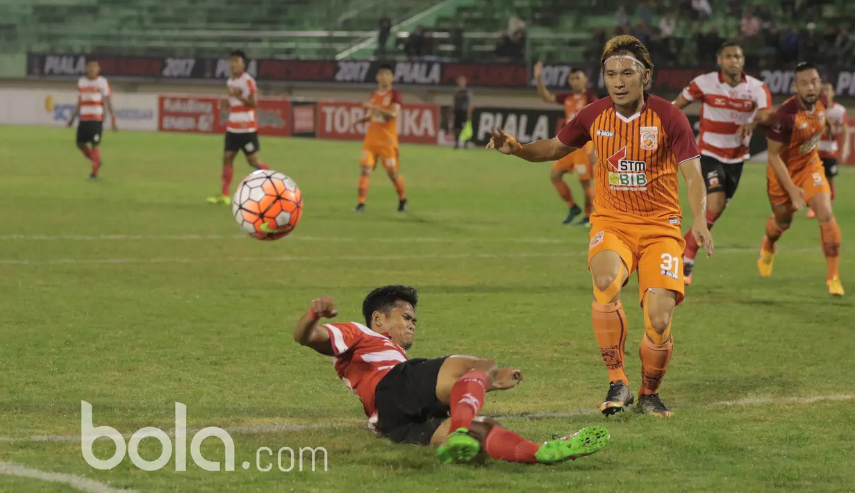 Pemain Pusamania Borneo FC, Michael Ora (kanan) menghadang pemain Madura United  pada babak delapan besar Piala Presiden 2017 di Stadion Manahan, Solo. Jumat (25/2/2017). (Bola.com/Nicklas Hanoatubun)