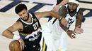 Pemain Denver Nuggets, Jamal Murray, berebut bola dengan pemain Utah Jazz, Royce O'Neale, pada ronde pertama playoff NBA musim 2020 di The Field House, Florida, Selasa (18/8/2020). Denver Nuggets menang 135-125 atas Utah Jazz. (AFP/Ashley Landis/Pool/Getty Images)