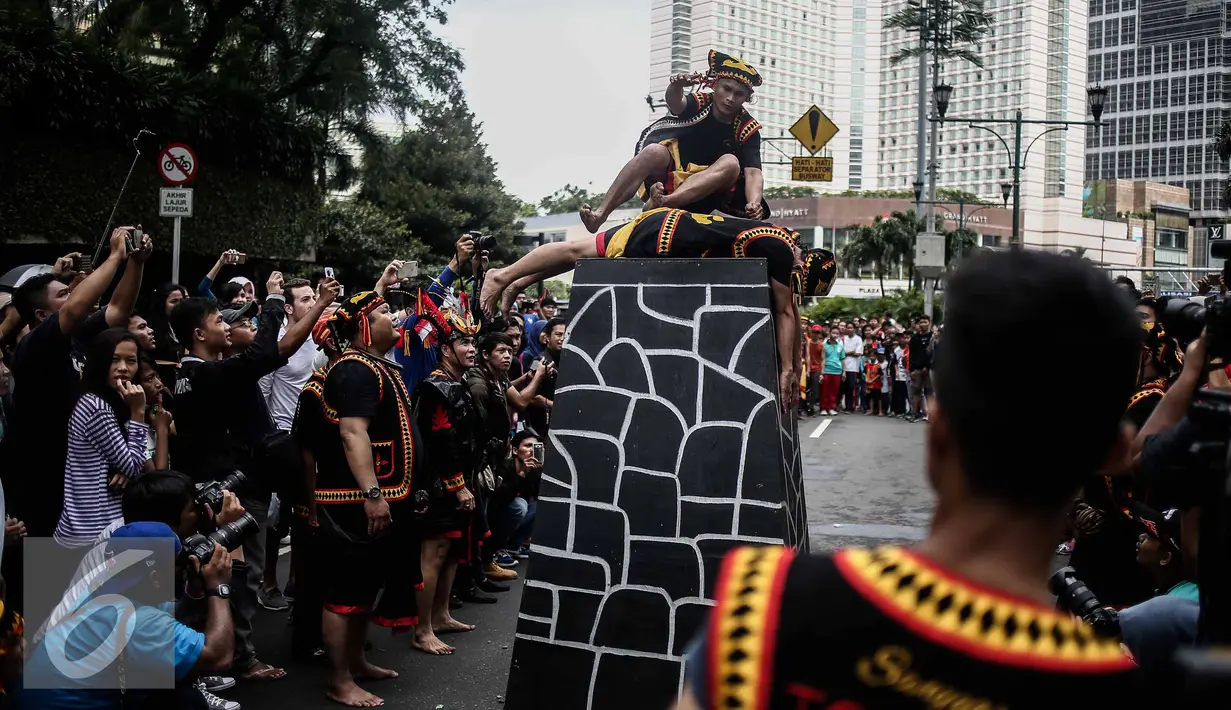 Atraksi seorang pria saat melakukan fahombo atau lompat batu dalam sebuah acara pagelaran seni dan kebudayaan Nias di Jalan Imam Bonjol, Jakarta, Minggu (12/2). Pagelaran ini diselenggarakan oleh Pemuda Peduli Nias. (Liputan6.com/Faizal Fanani)