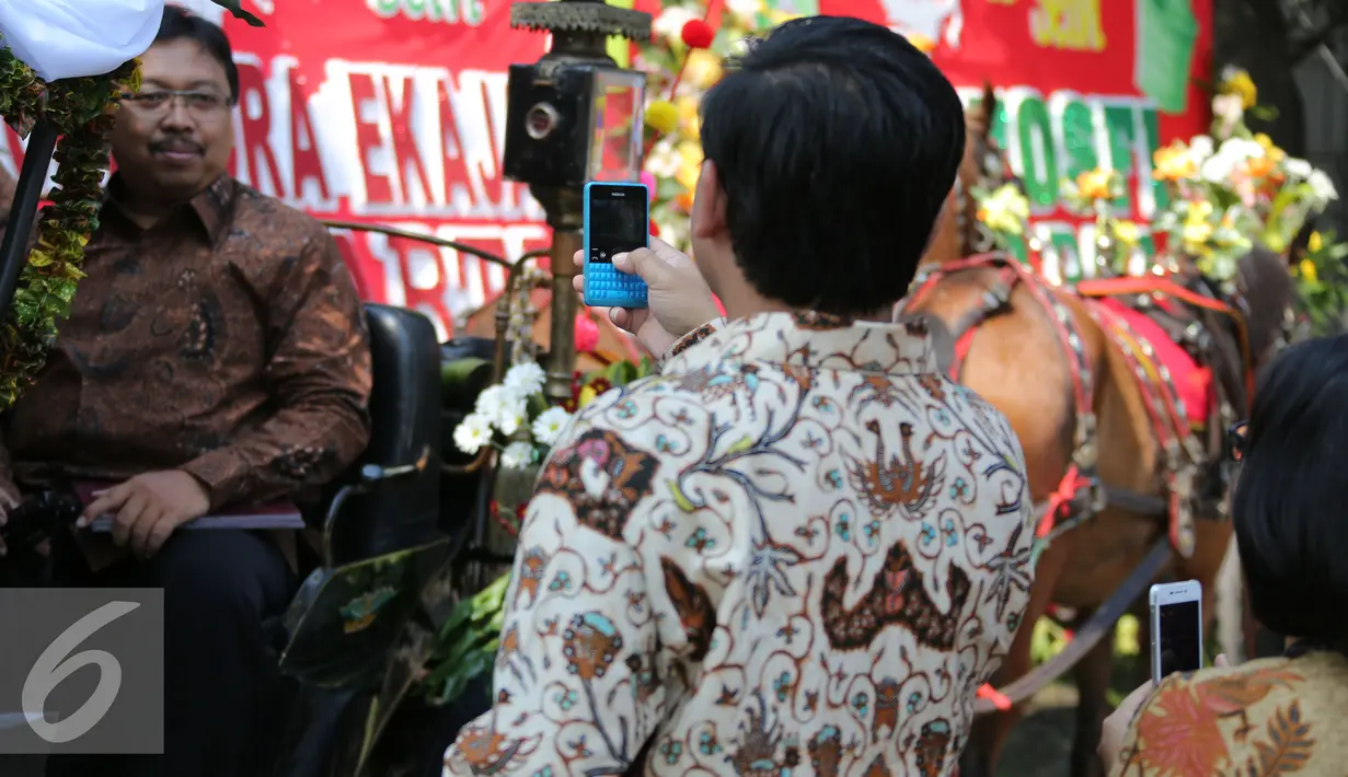 Sejumlah tamu undangan berfoto di kereta kencana pengiring pengantin Putra sulung Presiden Joko Widodo, Gibran Rakabuming Raka, Solo, Kamis (11/6/2015). Gibran menikahi Selvi Ananda dengan memakai adat Jawa. (Liputan6.com/Faizal Fanani) 
