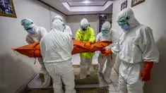 Tim penanganan bersiap membawa jenazah  pasien Covid-19 yang meninggal di rumah selama isolasi mandiri setelah rumah sakit setempat tidak dapat menampung pasien virus corona di Bogor, Jawa Barat (6/7/2021).  (AFP/ Aditya Aji)