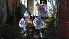 Anggota keluarga menyaksikan petugas pemakaman mengeluarkan jenazah Amelia Dias Nascimento (94) yang meninggal akibat komplikasi COVID-19 di rumahnya, di Manaus, negara bagian Amazonas (22/1/2021). Jumlah orang meninggal di rumah di tengah pandemi meningkat di Brasil. (AP Photo/Edmar Barros)