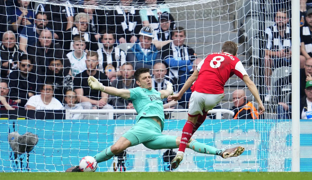 Penjaga gawang Newcastle United, Nick Pope (kiri), berhasil menggagalkan tendangan dari pemain Arsenal, Martin Odegaard, dalam laga pekan ke-35 Premier League 2022/2023 yang berlangsung di St James Park, Minggu (7/5/2023). (AP Photo/Jon Super)