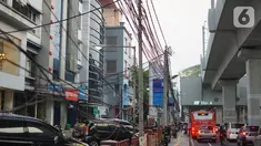Instalasi kabel menjuntai di Jalan Panglima Polim, Kebayoran Baru, Jakarta, Kamis (31/10/2019). Buruknya pemasangan instalasi kabel di Ibukota menyebabkan banyak kabel yang menjuntai hingga mengganggu ketertiban umum. (Liputan6.com/Immanuel Antonius)