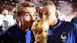 Pemain bintang timnas Prancis, Antoine Griezmann resmi mengumumkan pengunduran dirinya dari sepak bola internasional pada 30 September 2024. Tampak dalam foto, Antoine Griezmann (kiri) bersama Kylian Mbappe saat memenangi laga final Piala Dunia 2018. (FRANCK FIFE/AFP)