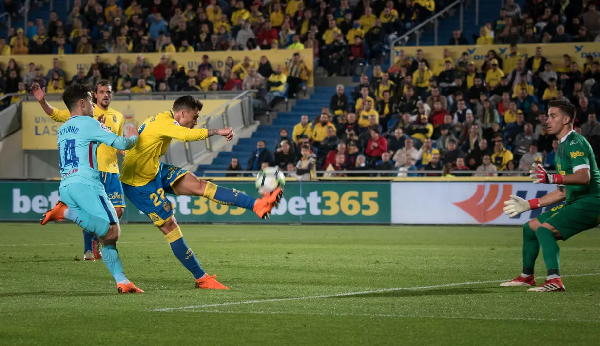 Pemain Las Palmas, Ximo Navarro Jimenez berebut bola dengan  pemain Barcelona Philippe Coutinho pada jornada ke-26 La Liga 2017-2018 di Estadio Gran Canaria, Kamis (1/3). Barcelona gagal menang karena tuan rumah menahan imbang 1-1. (DESIREE MARTIN/AFP)