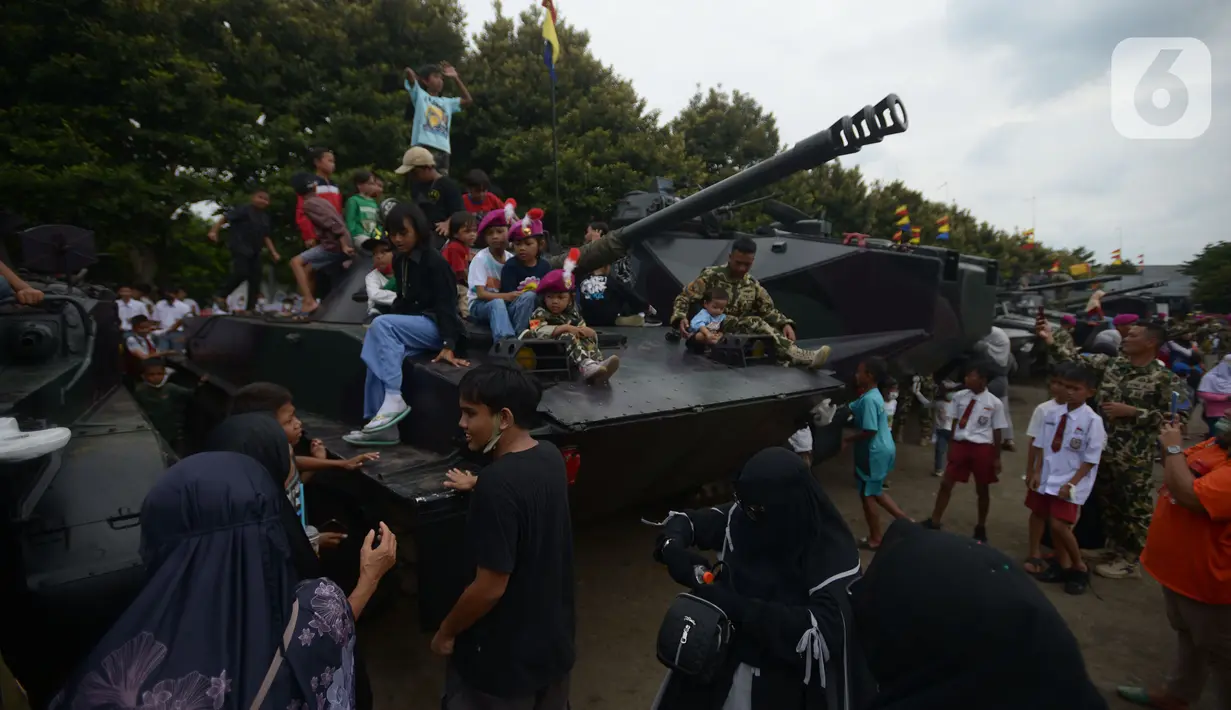 Warga naik tank berkeliling  di lapangan Marinir Cilandak, Jakarta, Selasa (15/11/2022). Kegiatan ini dilakukan dalam rangka peringatan HUT Ke-77 Korps Marinir dibuka untuk warga mencoba berkeliling markas Marinir. (merdeka.com/Imam Buhori)