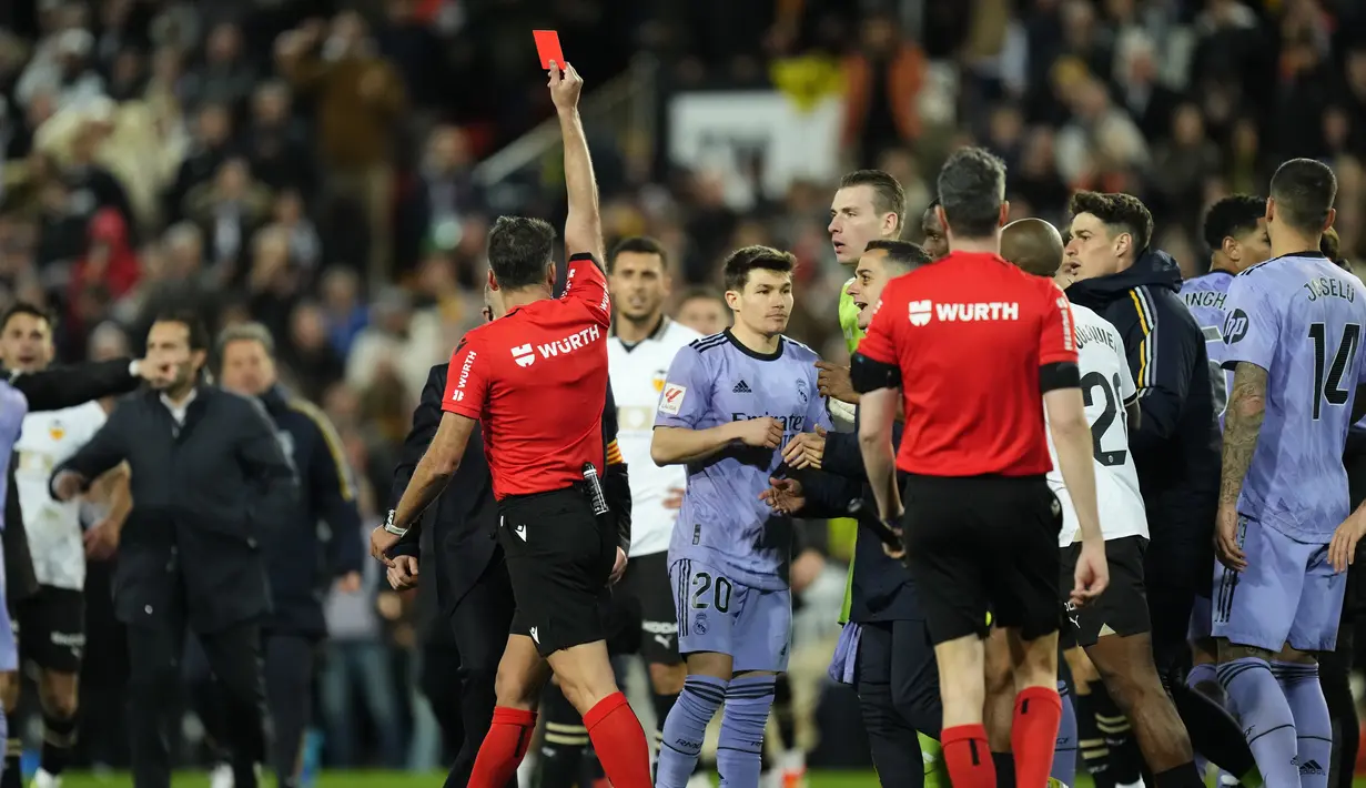 Wasit Gil Manzano memberikan kartu merah kepada pemain Real Madrid, Jude Bellingham, saat melawan Valencia pada laga Liga Spanyol pekan ke-27 di Stadion Mestalla, Minggu (3/3/2024). (AP Photo/Jose Breton)