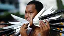 Seorang pemuja dari Kuil Samkong menusukkan senjata tajam pada pipinya ketika beratraksi dalam Festival Vegetarian di Phuket, Thailand, Selasa (4/10). (REUTERS/Jorge Silva)