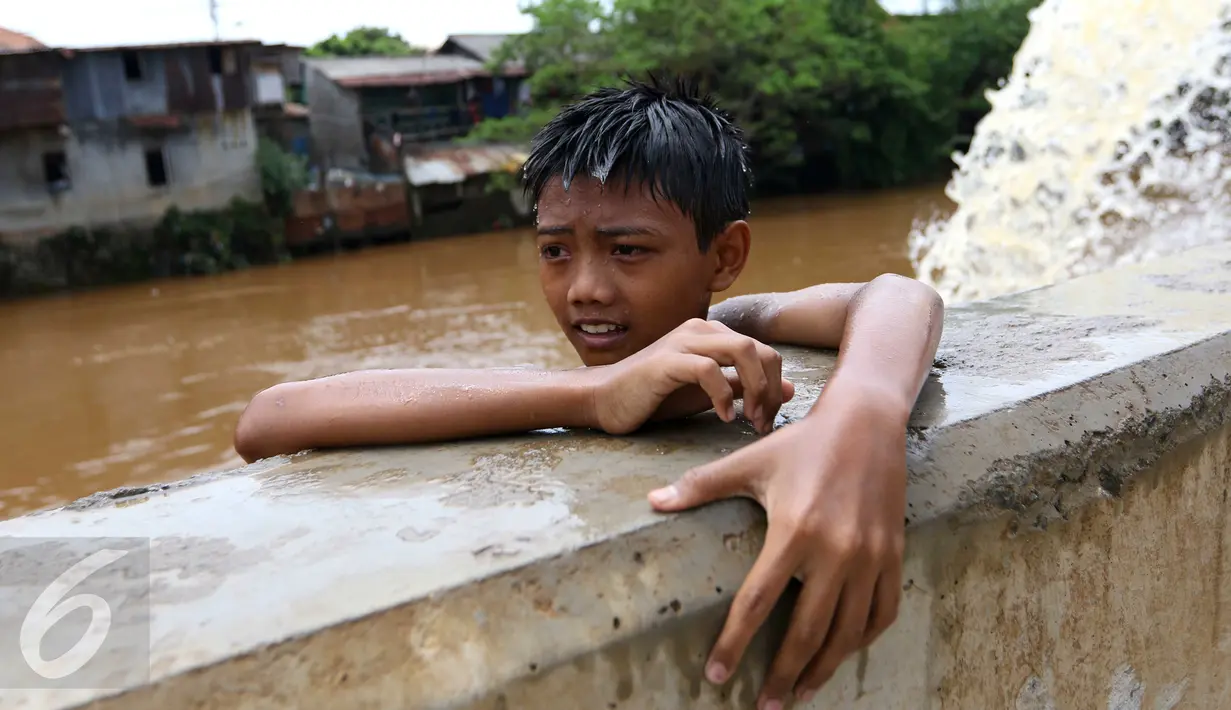 Seorang anak di bantaran kali Ciliwung, Kampung Pulo, Jakarta Timur, Sabtu (12/3). Warga memanfaatkan lahan di aliran sungai untuk tempat bermain karena minimnya lahan kosong di sekitar wilayah itu.(Liputan6.com/Gempur M Surya)