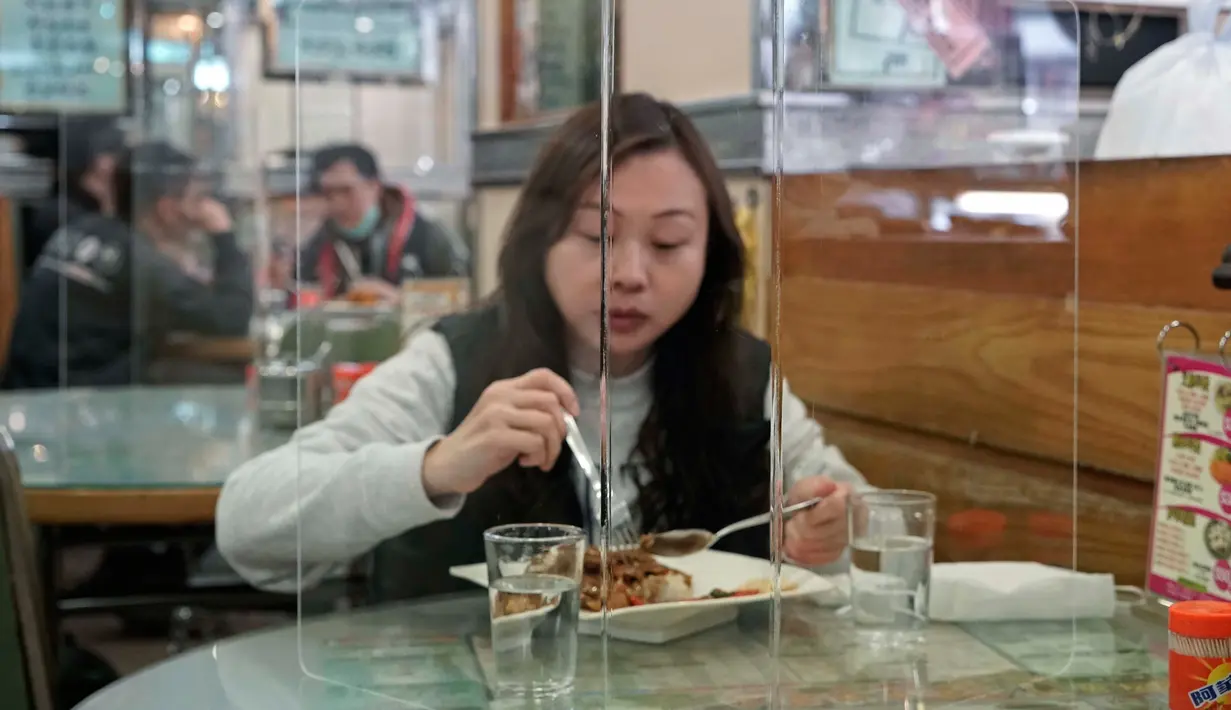 Pengunjung menikmati makan siang ditutupi panel plastik transparan untuk mengisolasi satu sama lain guna mencegah penyebaran virus corona di Hong Kong, 12 Februari 2020. WHO mengatakan wabah virus corona COVID-19 merupakan ancaman sangat besar bagi seluruh dunia. (AP/Kin Cheung)