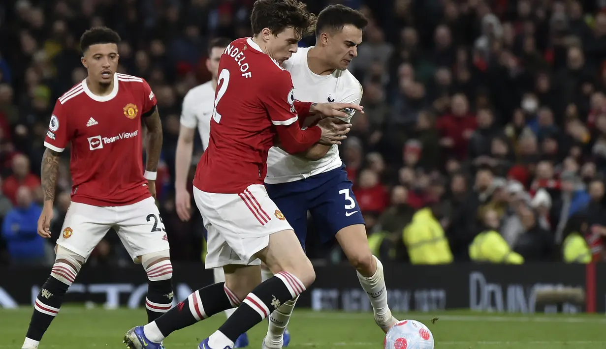 Bek Tottenham Hotspur Sergio Reguilon berebut bola dengan bek Manchester United (MU) Victor Lindelof pada pekan ke-29 Liga Inggris di Old Trafford, Minggu (13/3/2022) dini hari WIB. Ronaldo mencetak hattrick untuk membawa MU menang 3-2. (AP Photo/Rui Vieira)