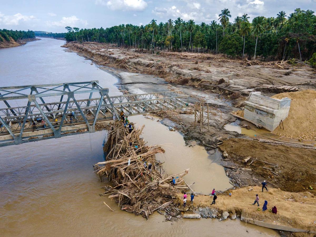 FOTO: Warga Memanjat Puing Kayu Demi Menyeberangi Sungai Peusangan