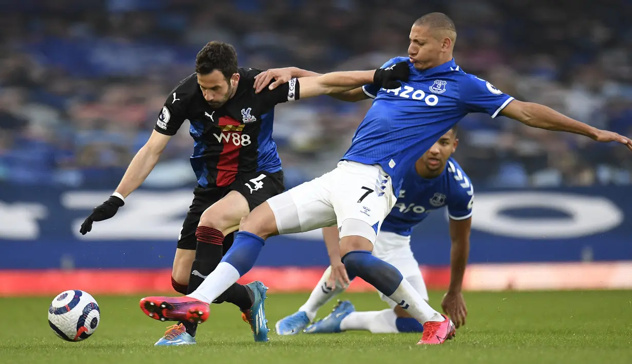 Gelandang Crystal Palace, Luka Milivojevic (kiri) bersaing dengan striker Everton, Richarlison pada pekan ke-30 Liga Inggris di Goodison Park, Selasa (6/4) dini hari WIB. Duel Everton vs Crystal Palace harus berakhir imbang dengan skor 1-1. (PETER POWELL / POOL / AFP)