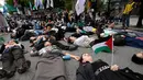Sejumlah warga yang menyatakan solidaritas terhadap Palestina berbaring di jalan saat mengikuti aksi yang mengecam tindakan militer Amerika Serikat dan Israel di Gaza, di Seoul, Korea Selatan, Sabtu (3/10/2026). Aksi die-in tersebut dilakukan sebagai simbol untuk menggambarkan korban konflik di Gaza. Para peserta berkumpul dan menyampaikan dukungan terhadap Palestina dalam unjuk rasa yang berlangsung di kawasan pusat Kota Seoul. (AP Photo/Ahn Young-joon)