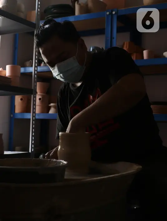 Perajin, Damar (39), menyelesaikan pembuatan produk berbahan tanah liat di Jurang Mangu, Tangerang Selatan, Sabtu (16/1/2021). Produksi keramik rumahan itu dipasarkan hingga luar pulau Jawa dengan harga Rp100 ribu - Rp300 ribu tergantung ukuran dan tingkat kesulitannya. (Liputan6.com/Angga Yuniar)