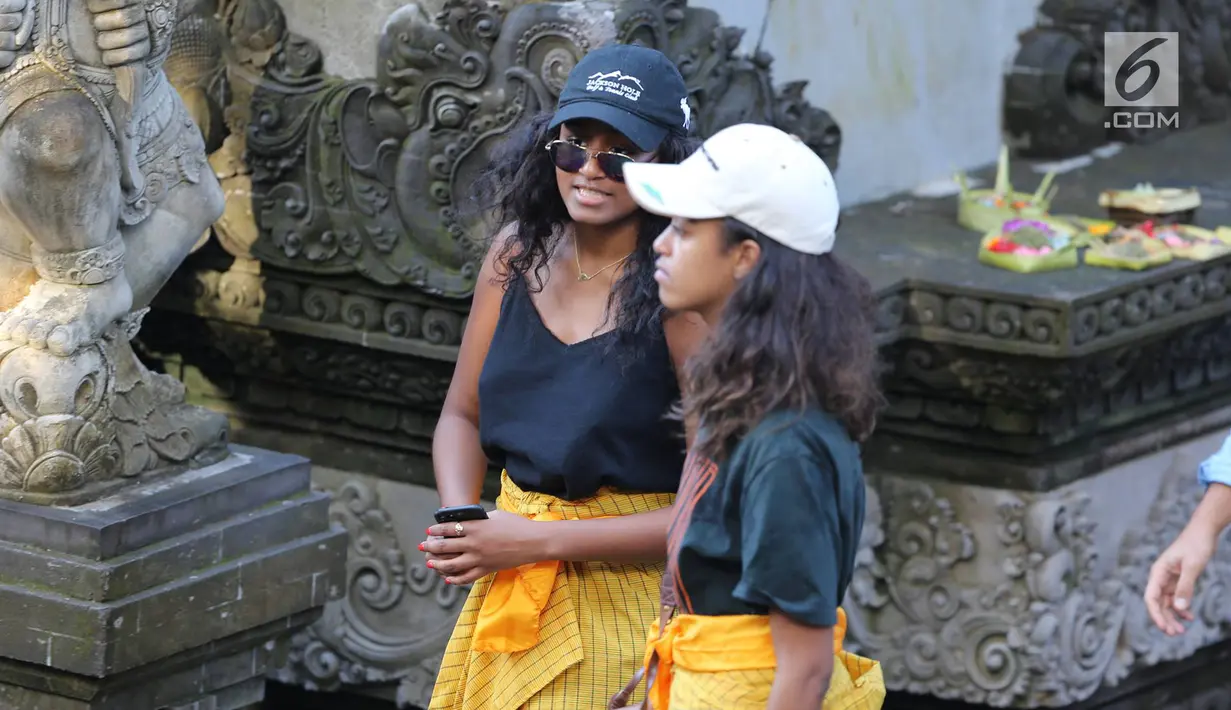 Dua putri Presiden ke-44 AS Barack Obama, Malia dan Sasha, mengunjungi Pura Tirta Empul, Tampaksiring, Gianyar, Bali, Selasa (27/6). Di pura bersejarah tersebut kedua putri Obama kompak mengenakan sarung warna kuning.  (Liputan6.com/Immanuel Antonius)