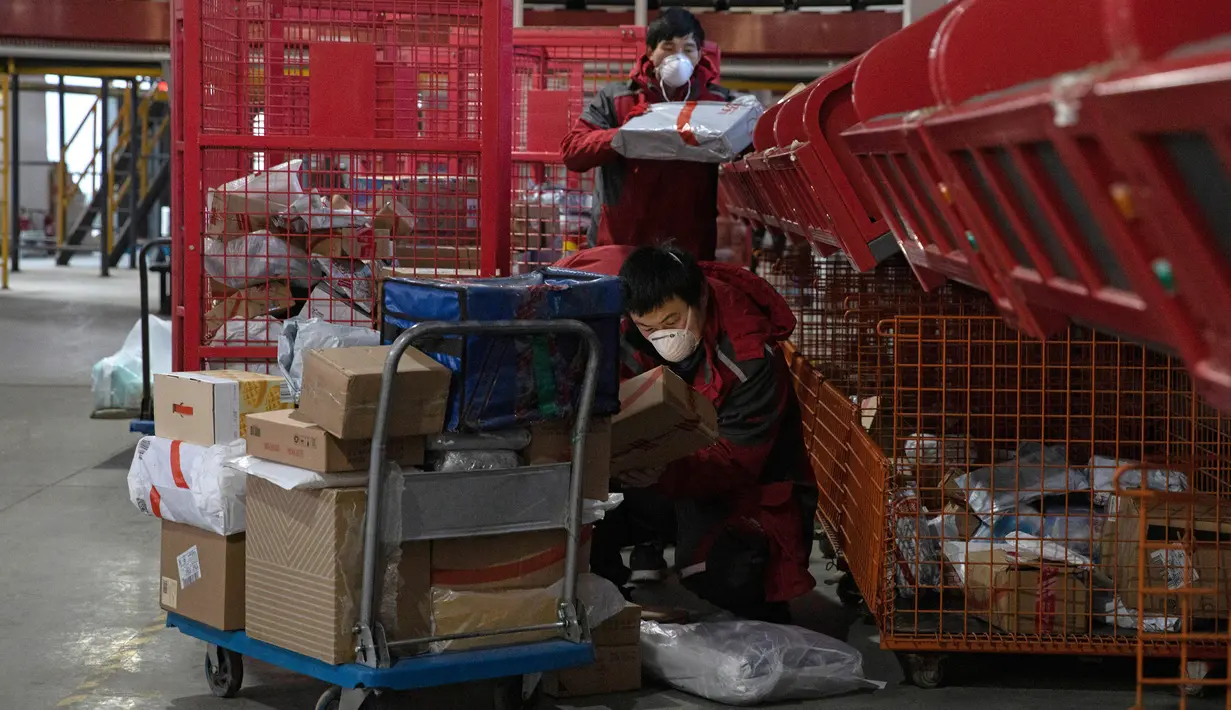 Kurir sibuk memilah paket di pusat distribusi di Beijing, China, Selasa (18/2/2020). E-commerce adalah salah satu dari sedikit industri yang berkembang setelah penutupan pabrik, restoran, bioskop, kantor, dan toko terkait wabah virus corona atau COVID-19. (AP Photo/Ng Han Guan)